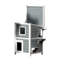 Grey and white two-tier wooden outdoor cat house with asphalt roof and viewing windows