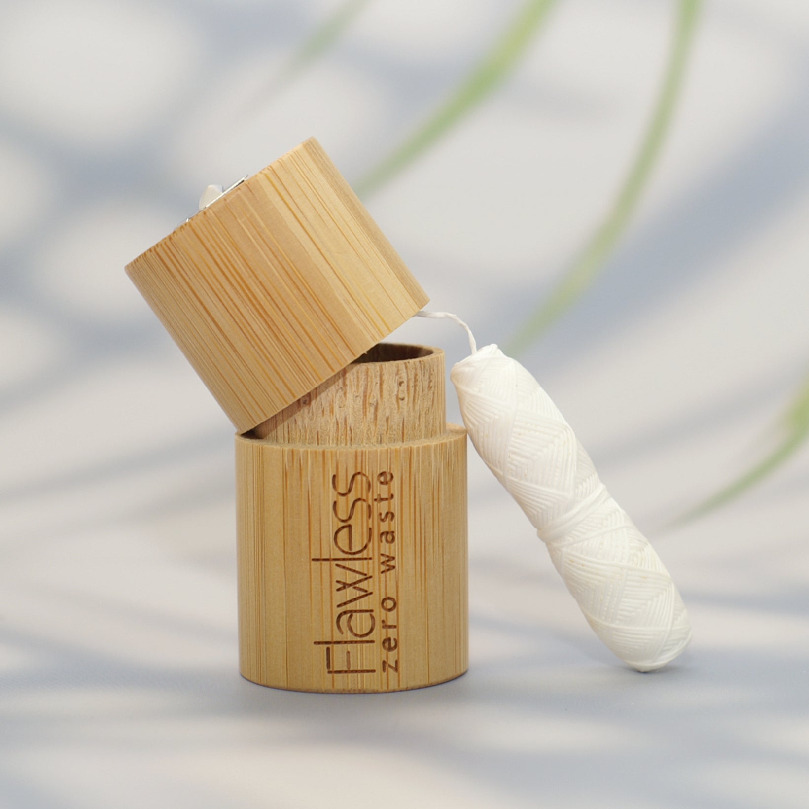Compostable peppermint dental floss in a reusable natural bamboo cylindrical dispenser
