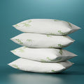 Four white bamboo fabric pillows stacked together with two firm and two medium support variations