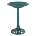 Green resin pedestal bird bath with copper verdigris effect on outdoor garden lawn