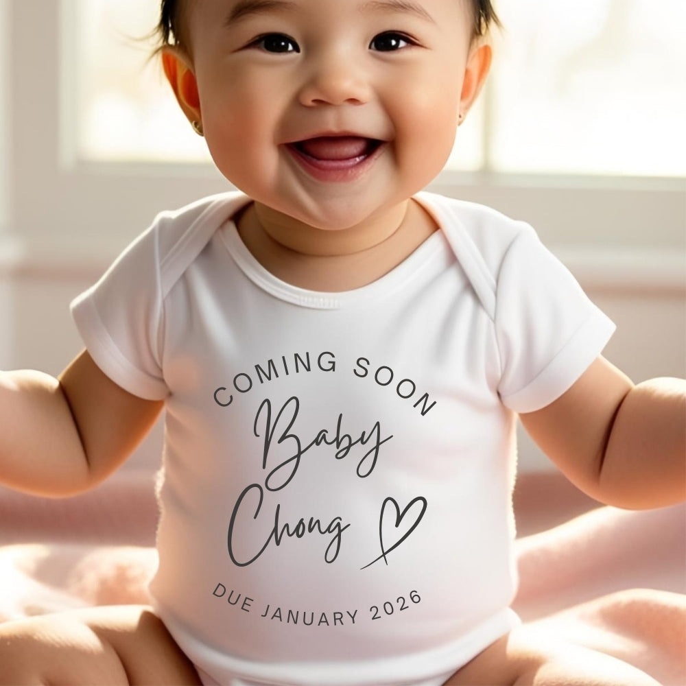 Personalised coming soon baby outfit in white with custom name and due date printed on front
