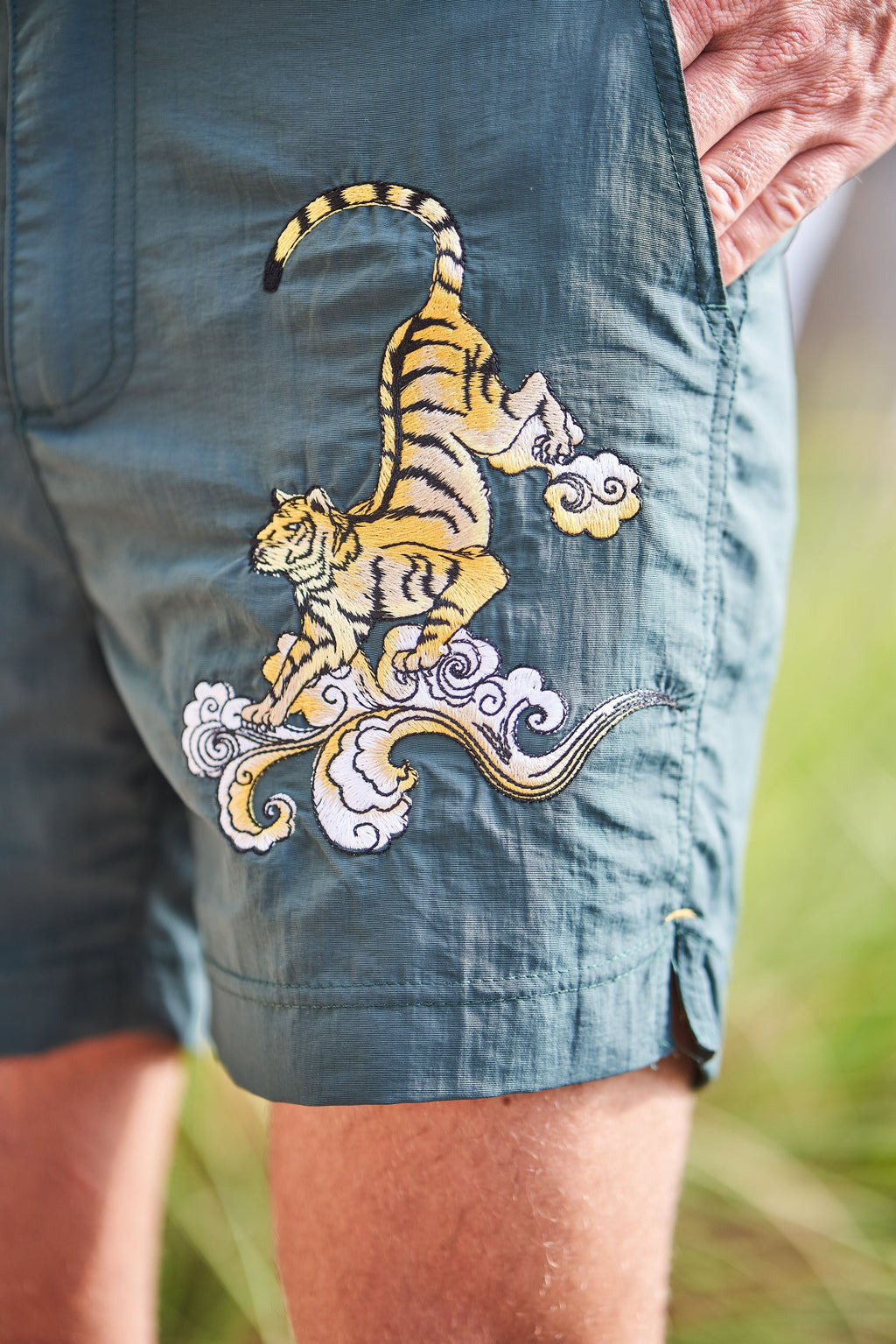 Dark green men's swim trunks with embroidered Japan tiger design, elastic waistband, and adjustable drawstrings. — view 3