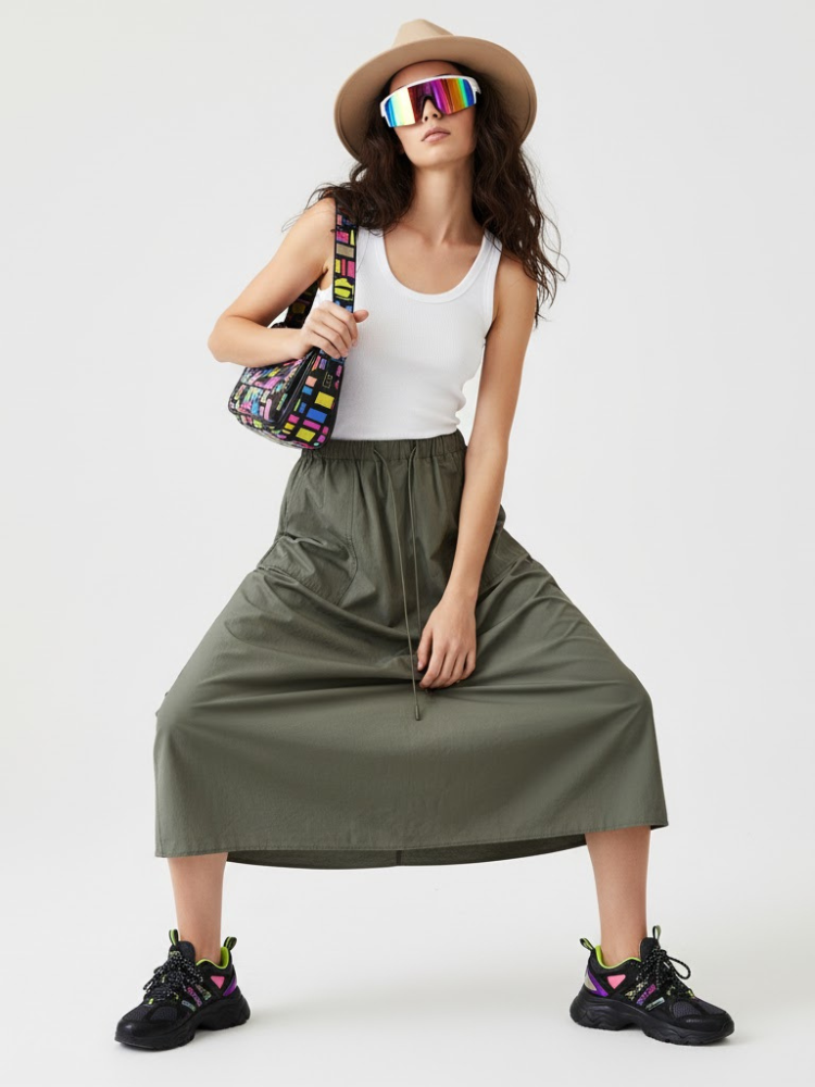 Asymmetric plaid maxi skirt in green and black with utilitarian layered panels and metallic buckle