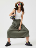 Asymmetric plaid maxi skirt in green and black with utilitarian layered panels and metallic buckle