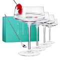 Four luxury glass martini coupes with an elegant silver mixing spoon for cocktail entertaining