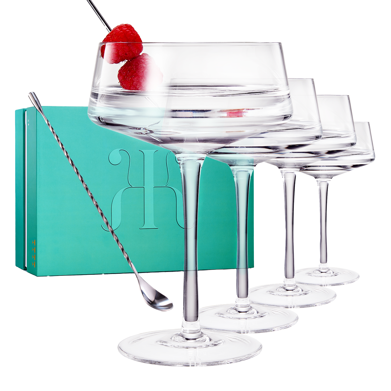 Four luxury glass martini coupes with an elegant silver mixing spoon for cocktail entertaining