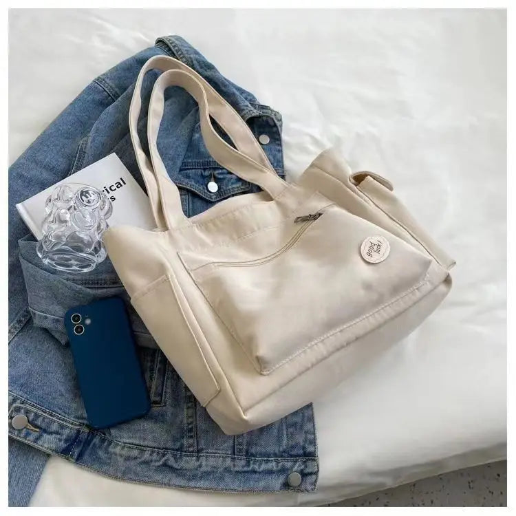 Beige canvas shoulder tote bag for women with embroidery details, rivets, and a secure zipper — view 2