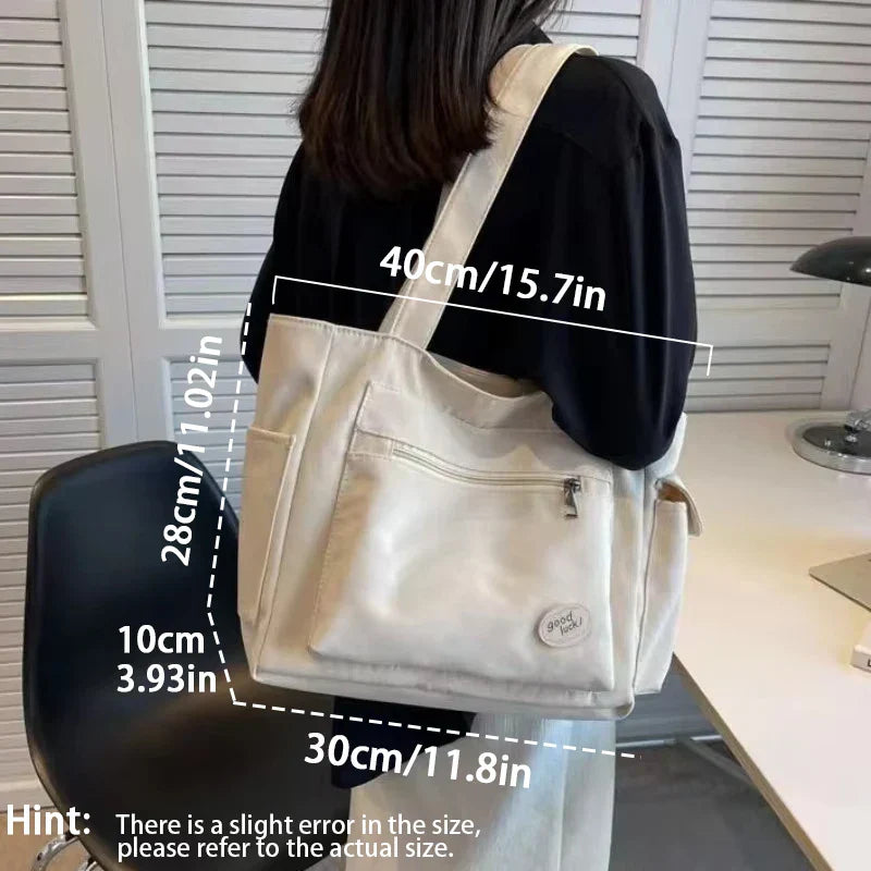 Beige canvas shoulder tote bag for women with embroidery details, rivets, and a secure zipper — view 5