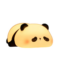Cute panda silicone LED night light emitting a warm glow on a bedside table