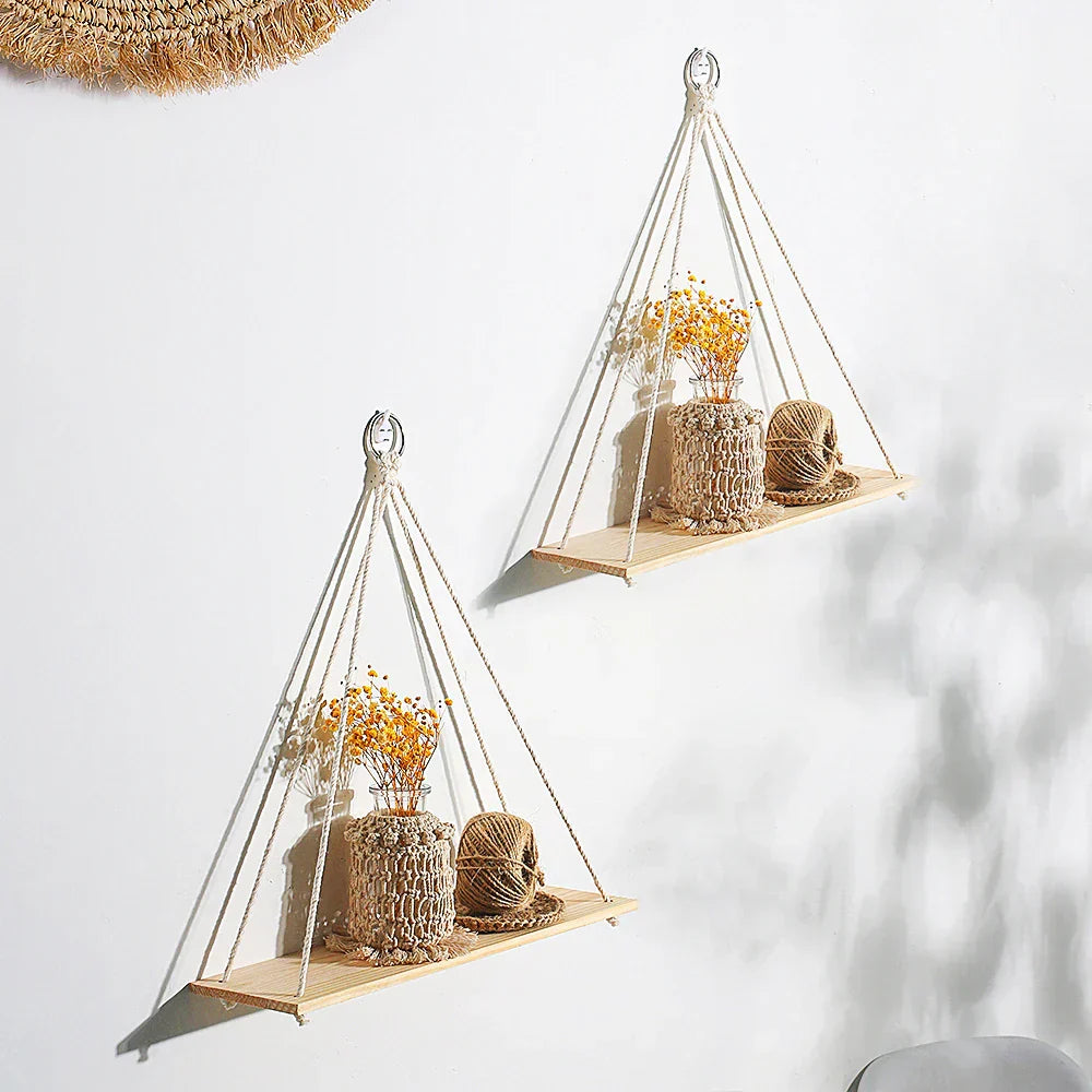 Handmade boho macrame wood wall shelf displaying small plants and home decor items against a wall