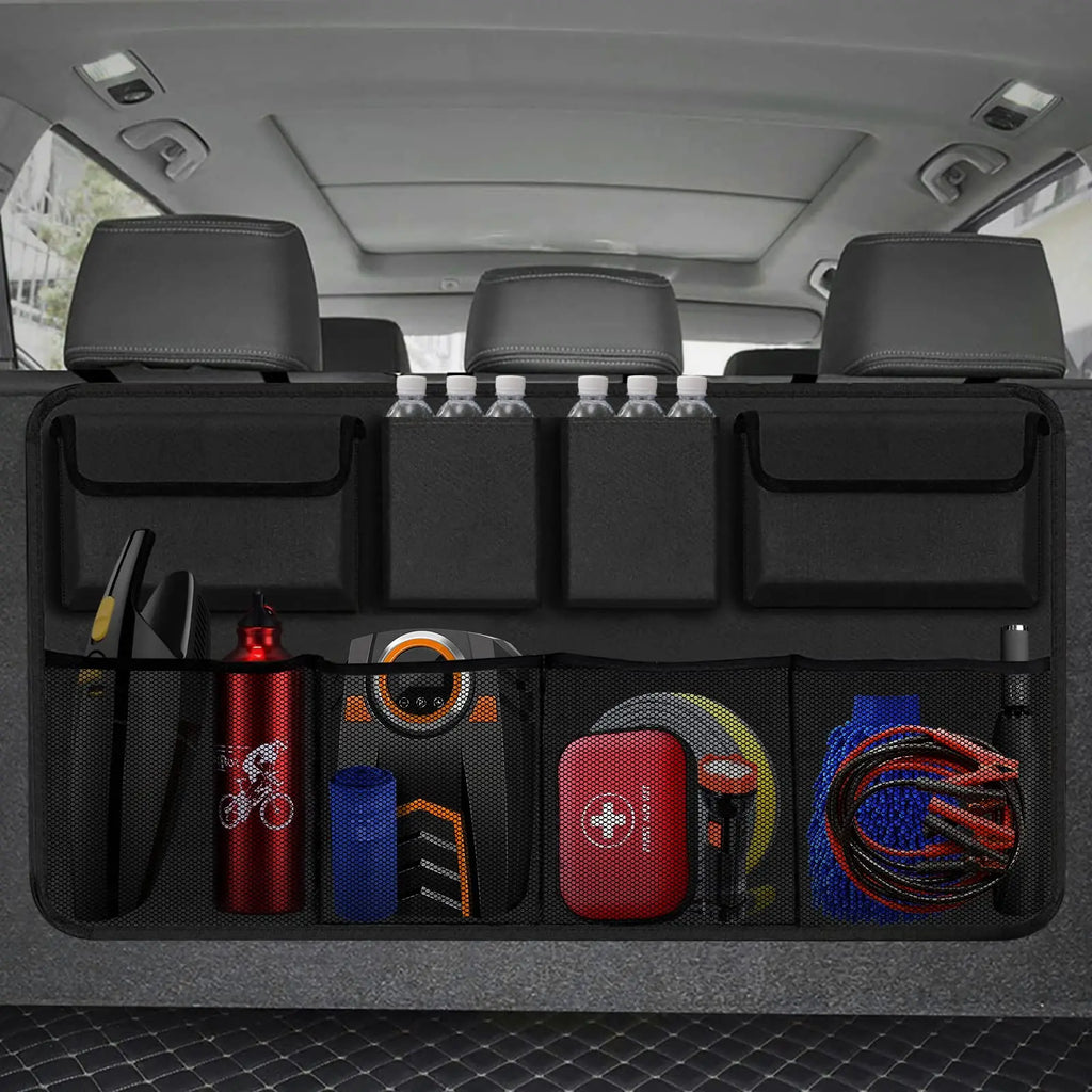 Black hanging car trunk organizer with 8 large storage pockets attached to vehicle backseat headrests — view 2
