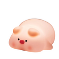Cute pig night light made of soft white silicone emitting a warm glow on a desk