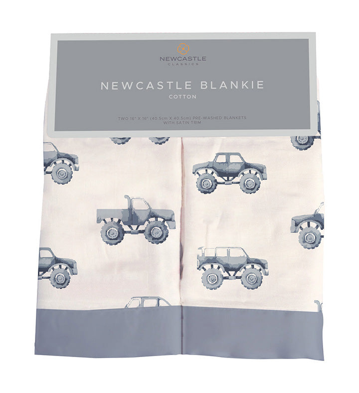 Indigo monster trucks printed cotton muslin security blanket for babies, folded neatly on display