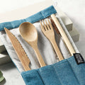 Bamboo travel cutlery set with green pouch, including a wooden fork, knife, spoon, and straw