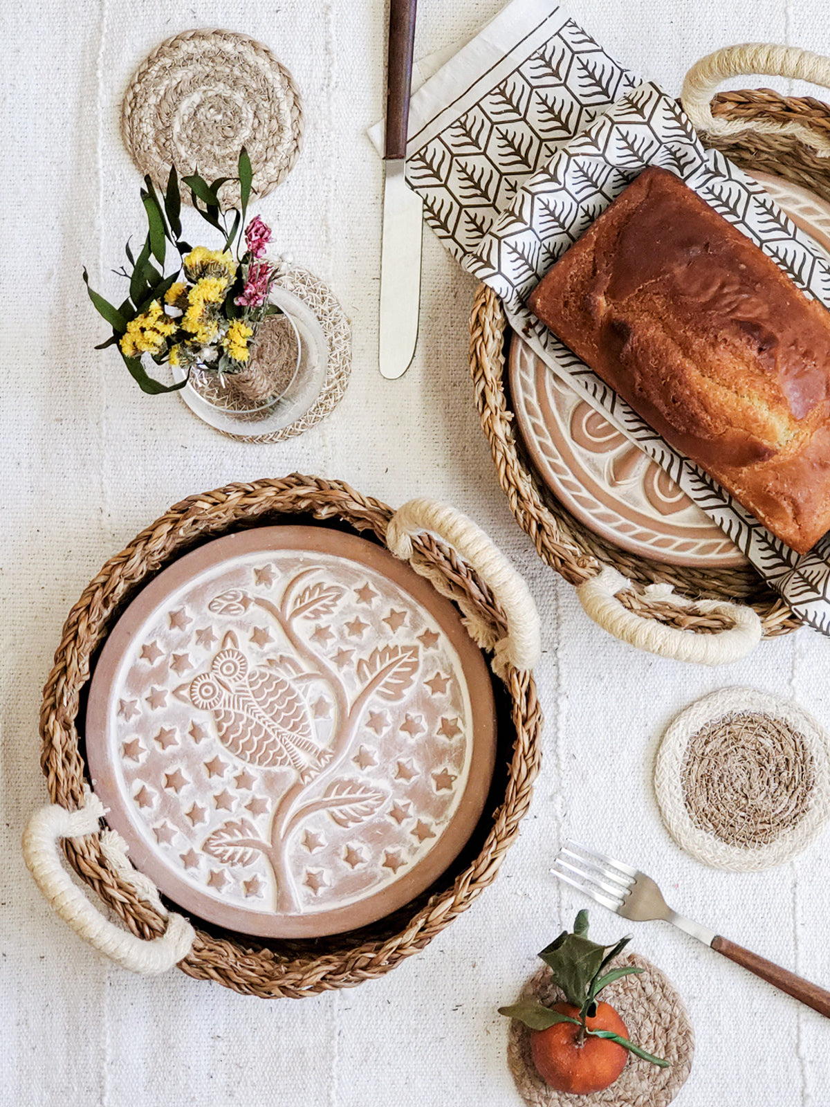Owl terracotta bread warmer stone in a woven seagrass basket with a printed cotton tea towel — view 2