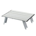 Foldable mini camping table in silver aluminum alloy set up outdoors for a picnic or barbecue