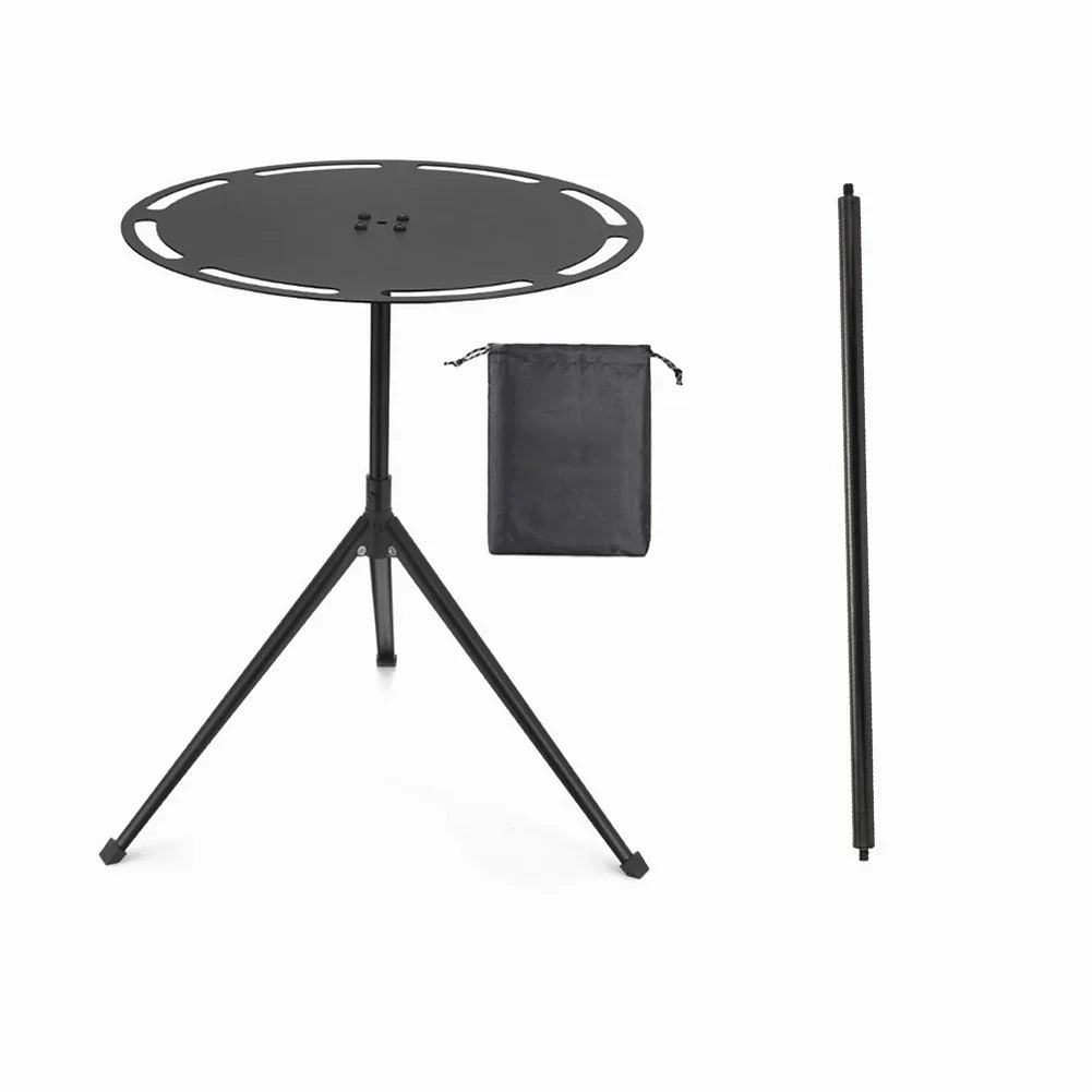 Portable round camping table with telescopic light pole and tripod base on outdoor terrain