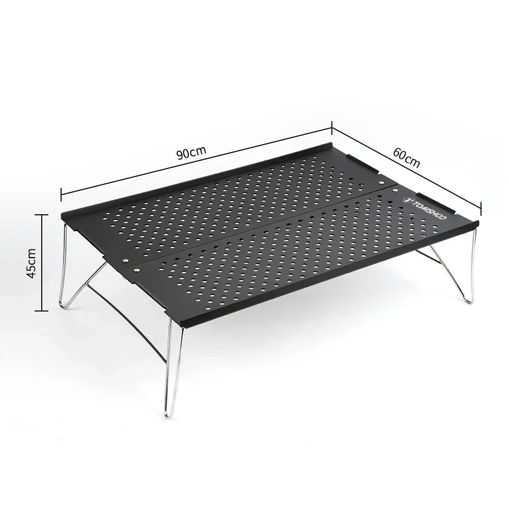 Compact metal folding camping table set up outdoors on green grass for a picnic — view 2