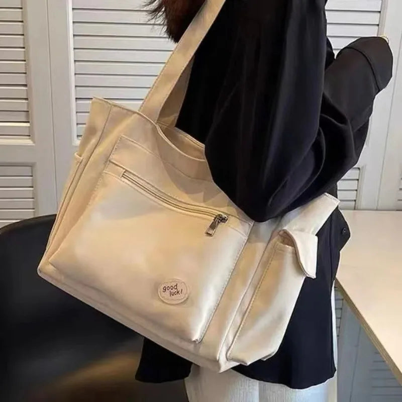 Beige canvas shoulder tote bag for women with embroidery details, rivets, and a secure zipper — view 3