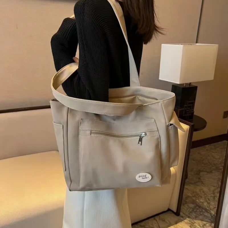 Beige canvas shoulder tote bag for women with embroidery details, rivets, and a secure zipper — view 4