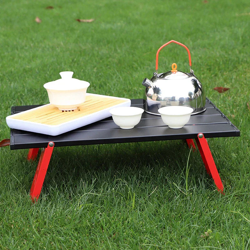 Portable foldable camping table with carry bag set up for an outdoor picnic or barbecue
