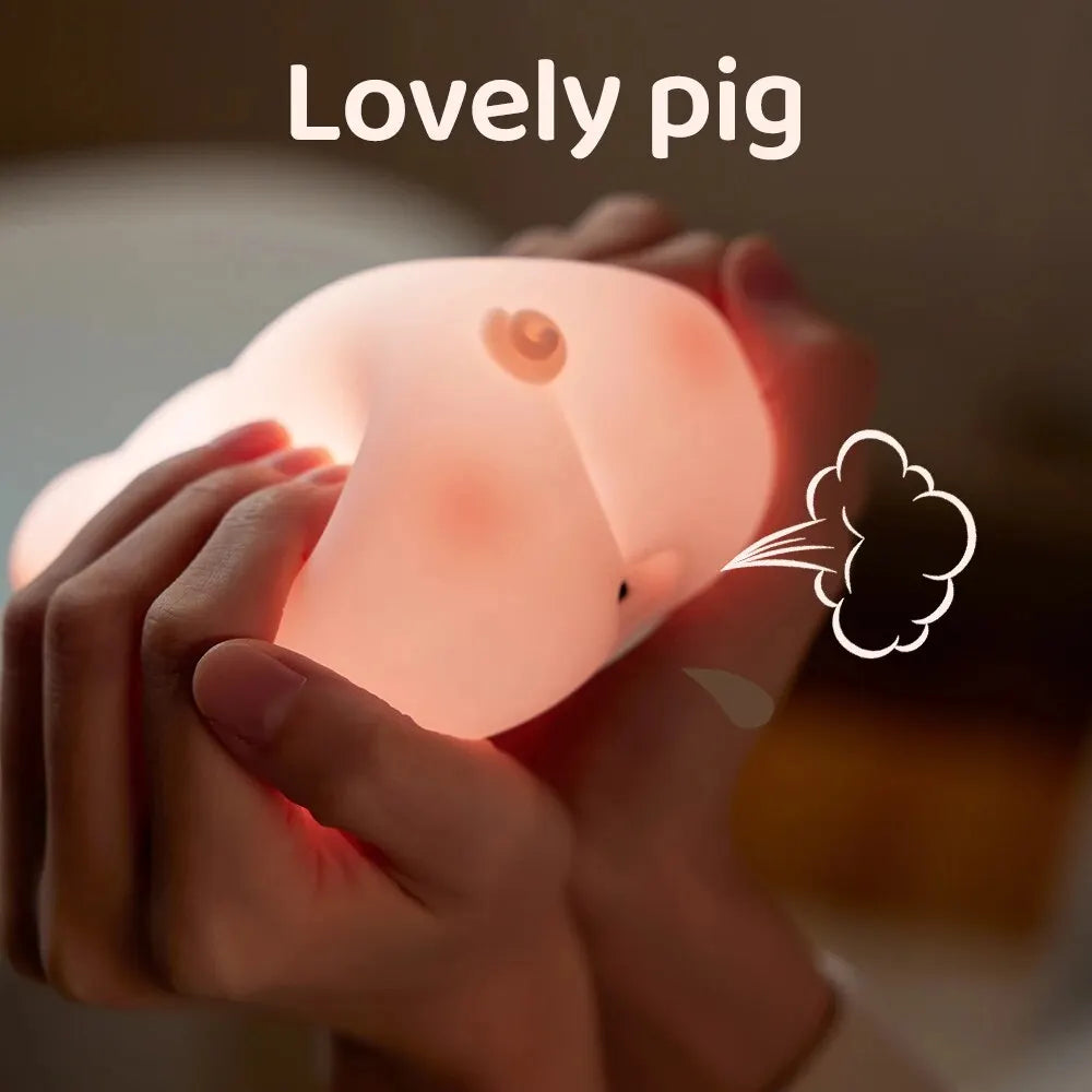 Cute pig night light made of soft white silicone emitting a warm glow on a desk — view 5