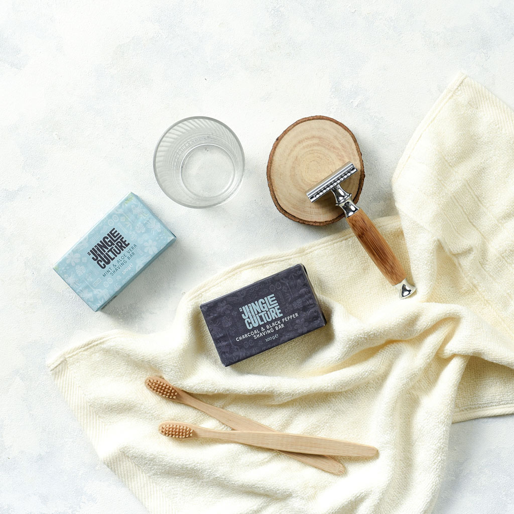 Reusable bamboo safety razor with long wooden handle and stainless steel head alongside kraft packaging — view 4