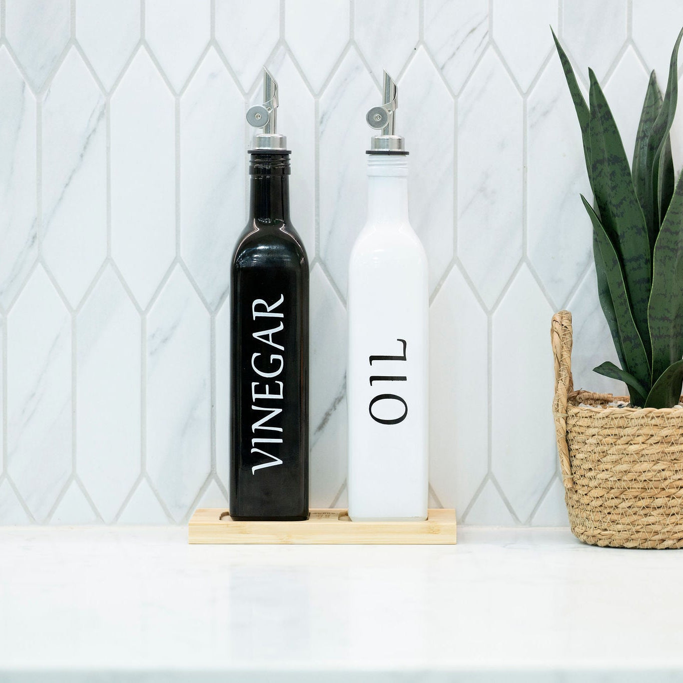 Black and white opaque glass oil and vinegar dispenser bottles on a smooth bamboo tray — view 4