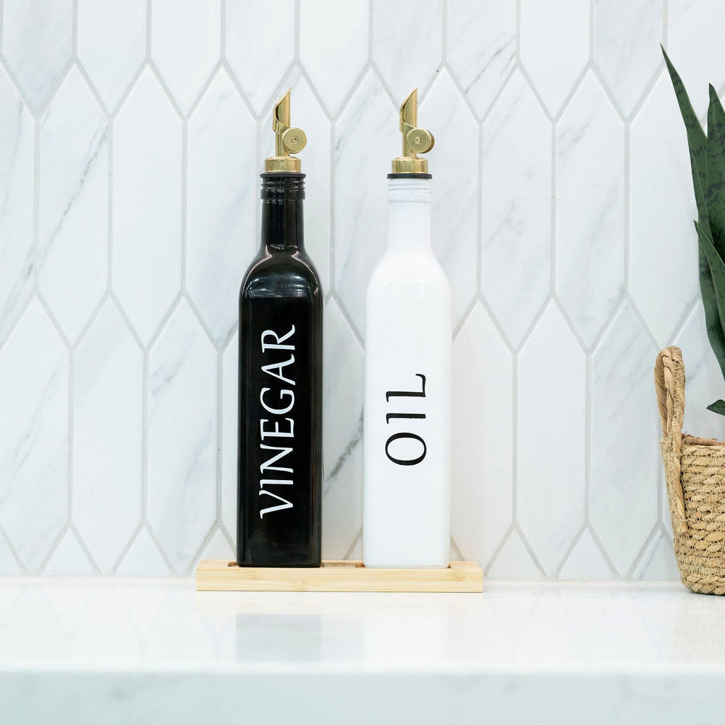 Black and white opaque glass oil and vinegar dispenser bottles on a smooth bamboo tray — view 3