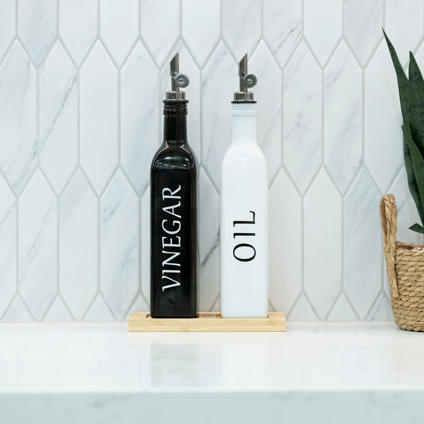 Black and white opaque glass oil and vinegar dispenser bottles on a smooth bamboo tray — view 5