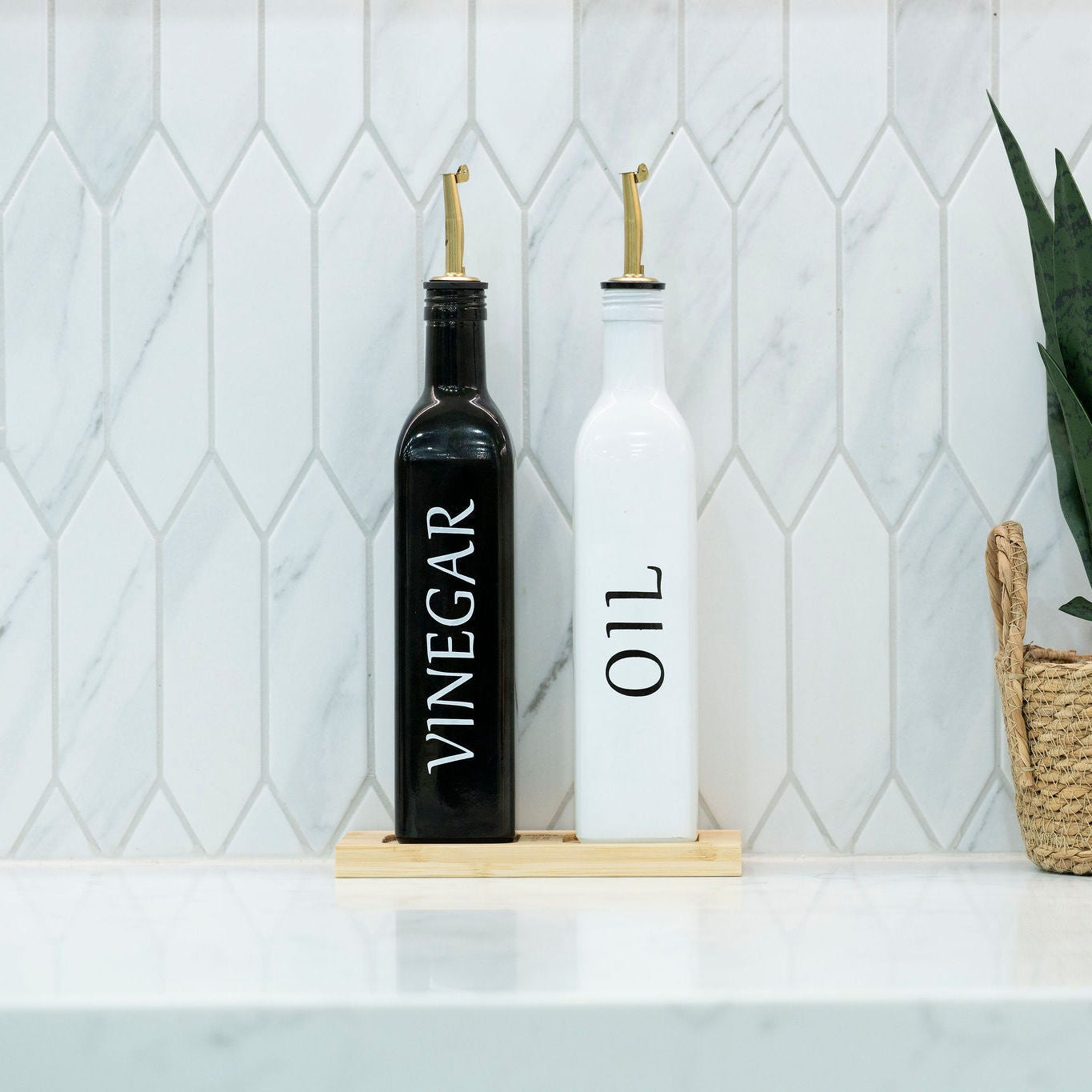 Black and white opaque glass oil and vinegar dispenser bottles on a smooth bamboo tray — view 2