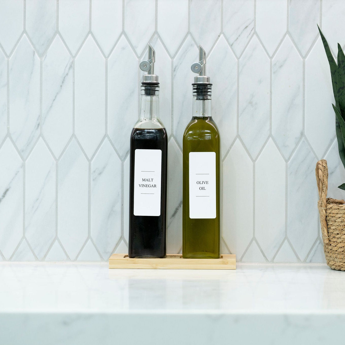 Two 500ml clear glass oil and vinegar bottles with metal pourers on a natural bamboo tray — view 4