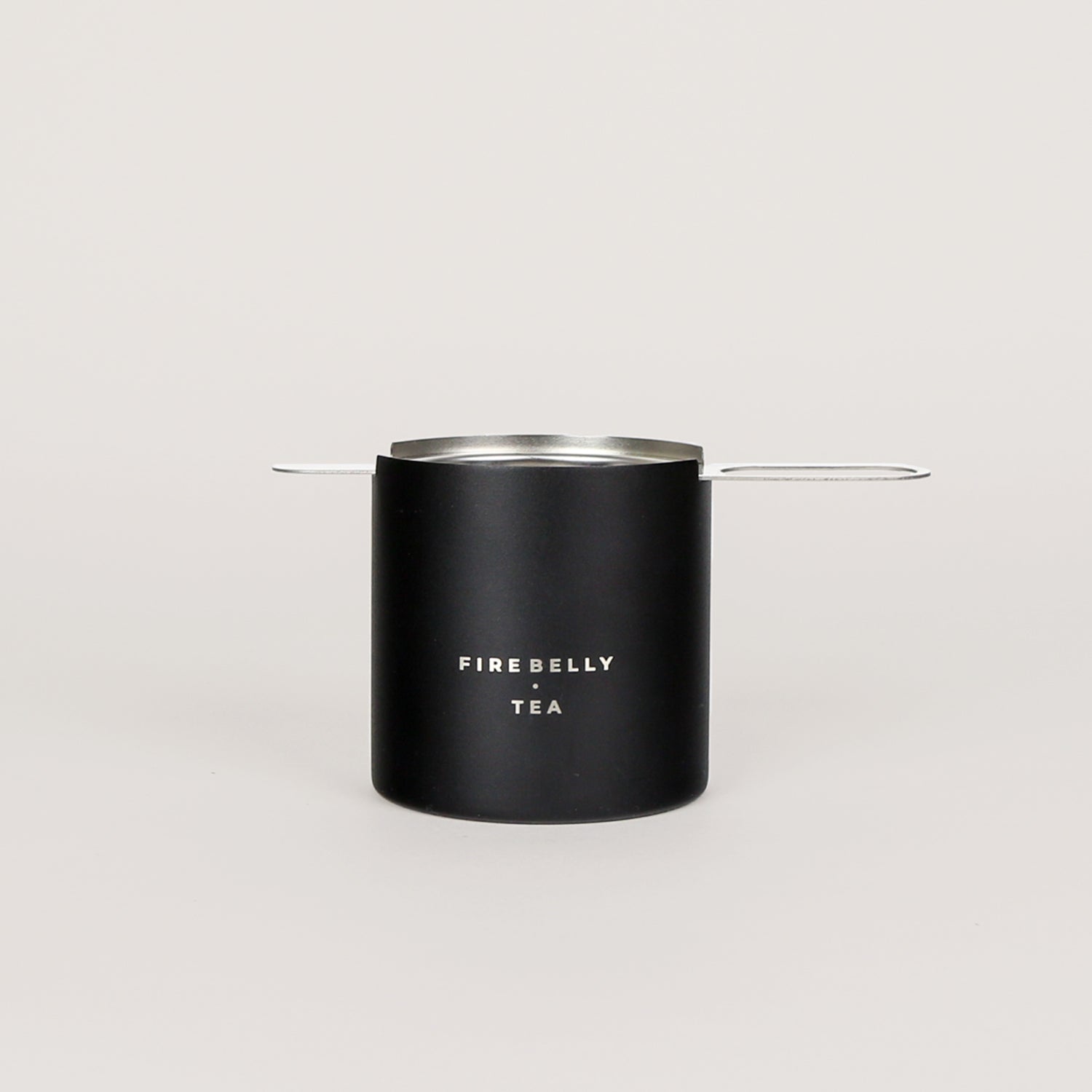 Black loose leaf tea strainer and fine mesh infuser resting on a matching catch cup. — view 5