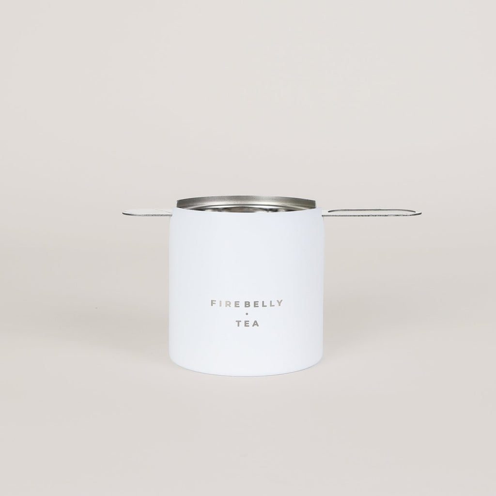 Black loose leaf tea strainer and fine mesh infuser resting on a matching catch cup. — view 4