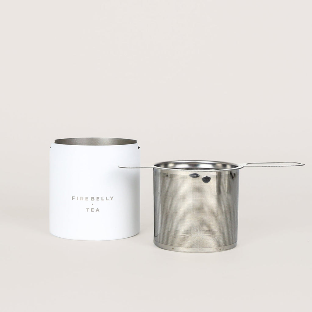 Black loose leaf tea strainer and fine mesh infuser resting on a matching catch cup. — view 2