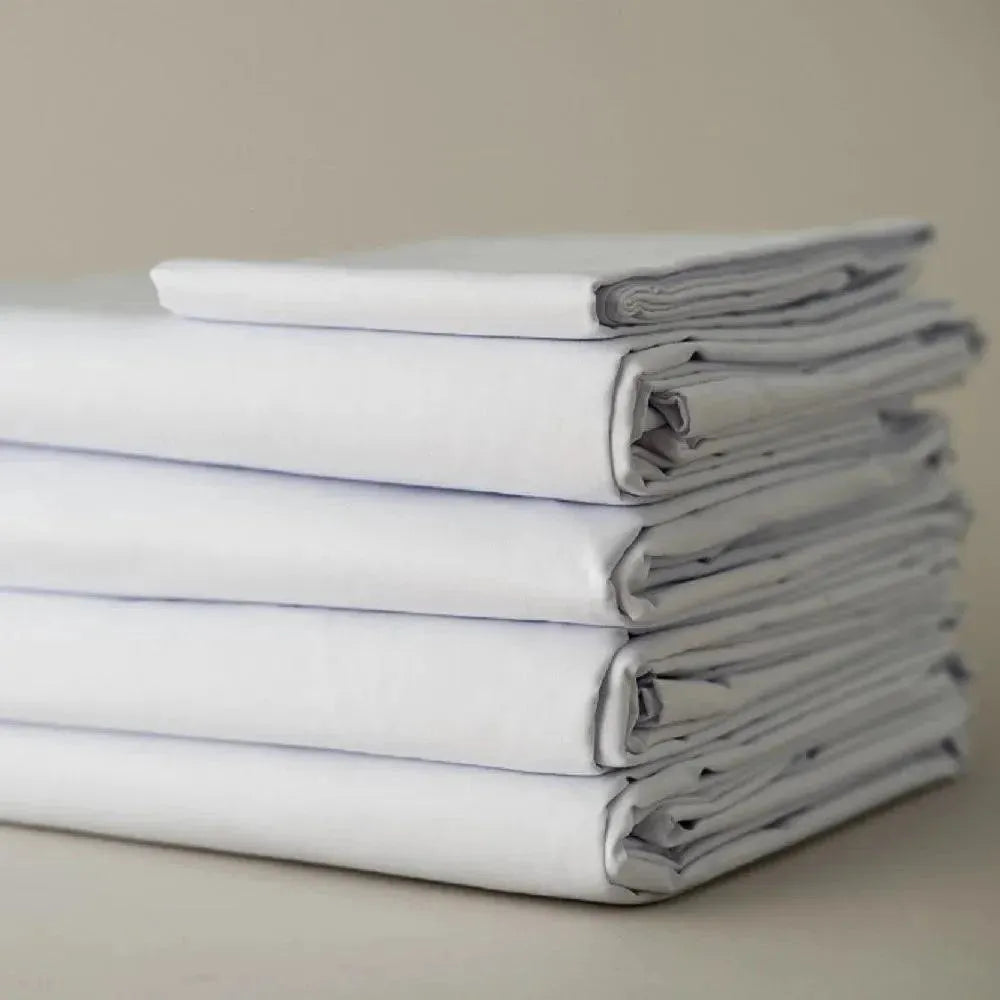 Folded stack of crisp T-300 white combed cotton bed sheets with matching pillowcases — view 5