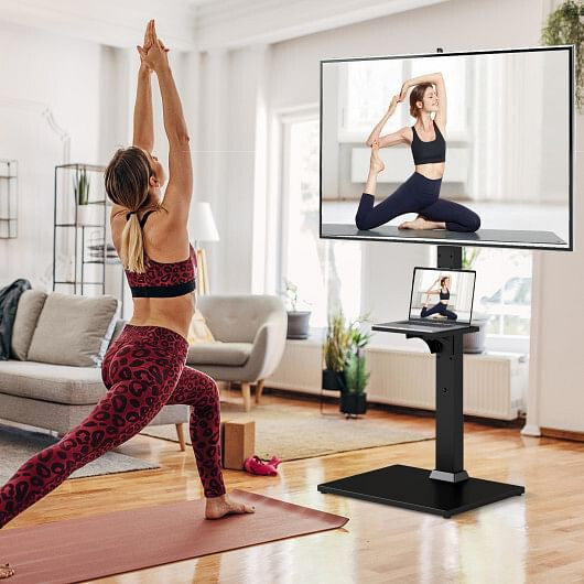 Black adjustable floor TV stand with built in power outlet, media shelves, and flat screen — view 2