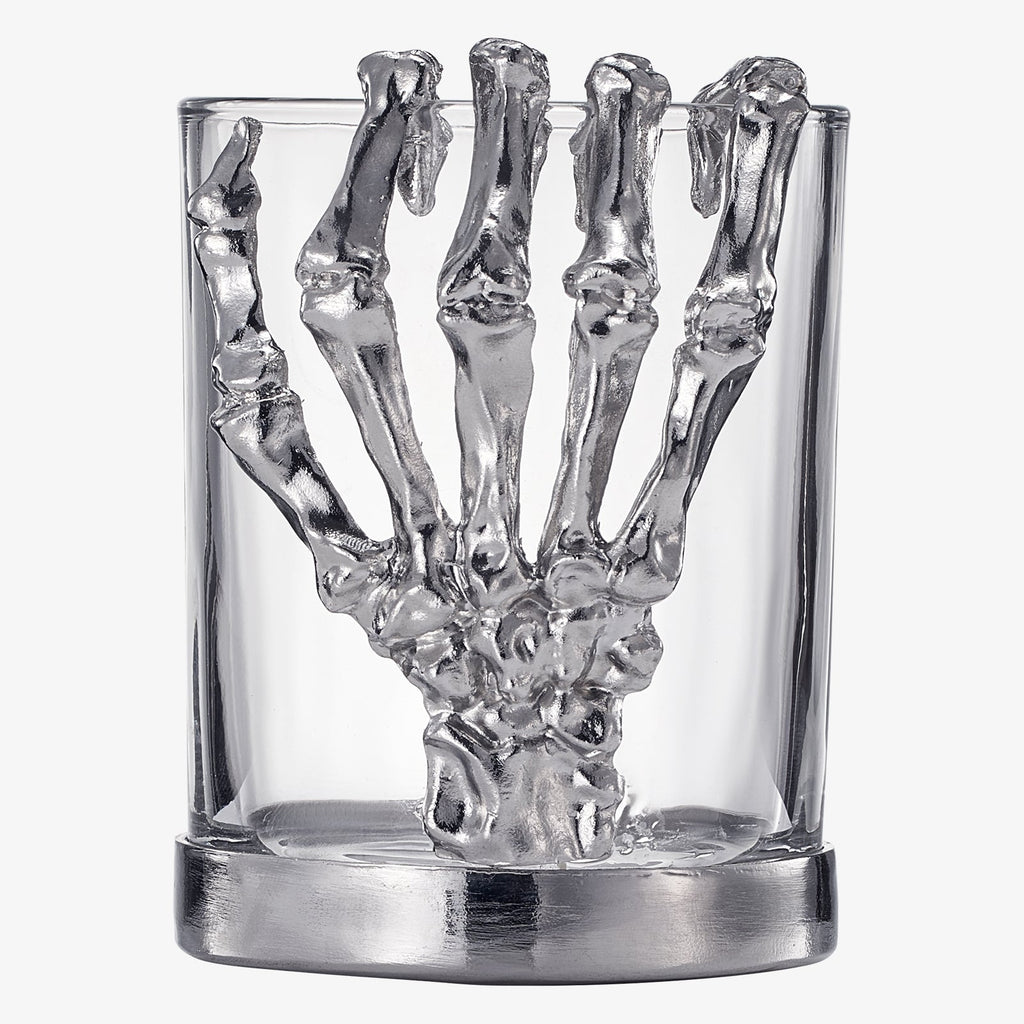 Skeleton whiskey glass tumbler with detailed bone hand stem, clear glass cup holding amber liquor — view 5