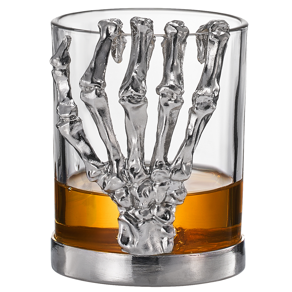 Skeleton whiskey glass tumbler with detailed bone hand stem, clear glass cup holding amber liquor
