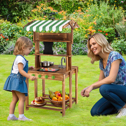 Double-sided wooden mud kitchen for kids with striped canopy, chalkboard, and cooking accessories