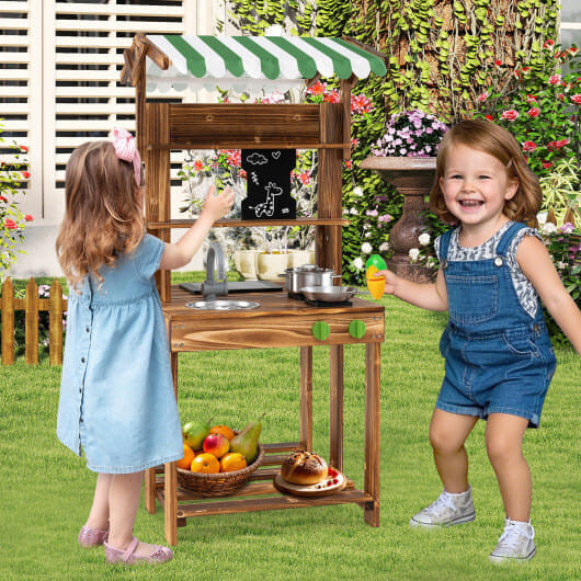 Double-sided wooden mud kitchen for kids with striped canopy, chalkboard, and cooking accessories — view 2
