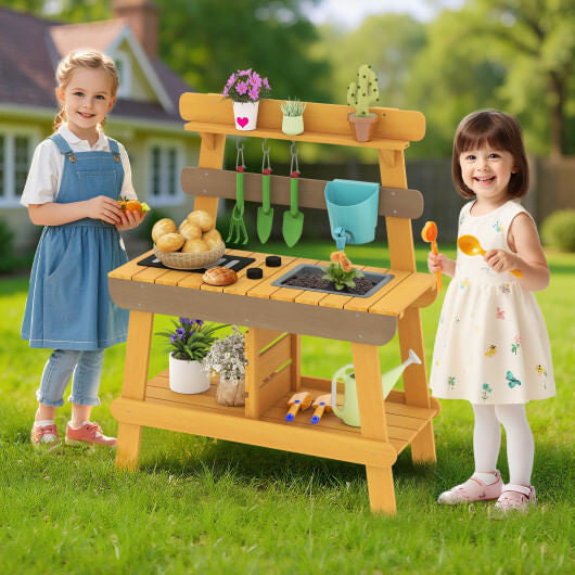 Yellow wooden outdoor mud kitchen for kids with play sink, grill, and gardening tools. — view 2