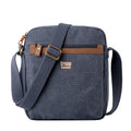 Classic stonewashed canvas crossbody bag with adjustable shoulder strap, brass buckles, and multiple zip pockets.