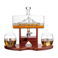 Hand-blown glass whiskey decanter with an antique ship inside, mahogany stand, and two glasses.