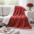 Red faux fur throw blanket with embossed hearts and fluffy white sherpa backing draped on couch