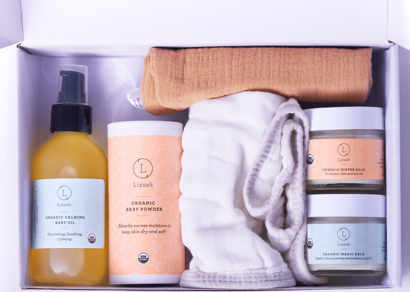 Organic baby skincare gift set in beautiful box featuring balms, oils, powder, and soft bibs — view 3