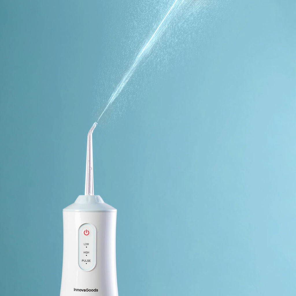 Portable blue and white cordless water flosser with interchangeable cleaning heads and USB cable. — view 14