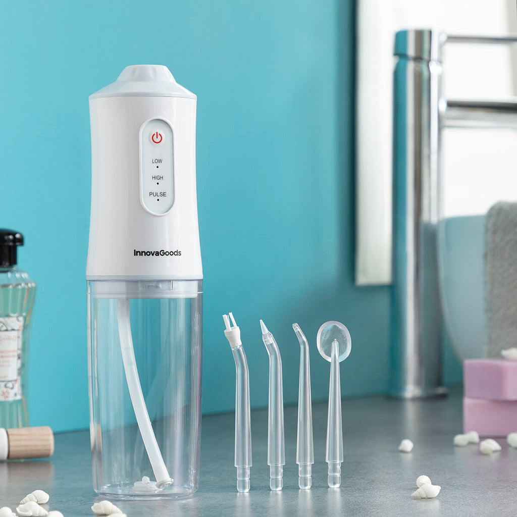 Portable blue and white cordless water flosser with interchangeable cleaning heads and USB cable. — view 13