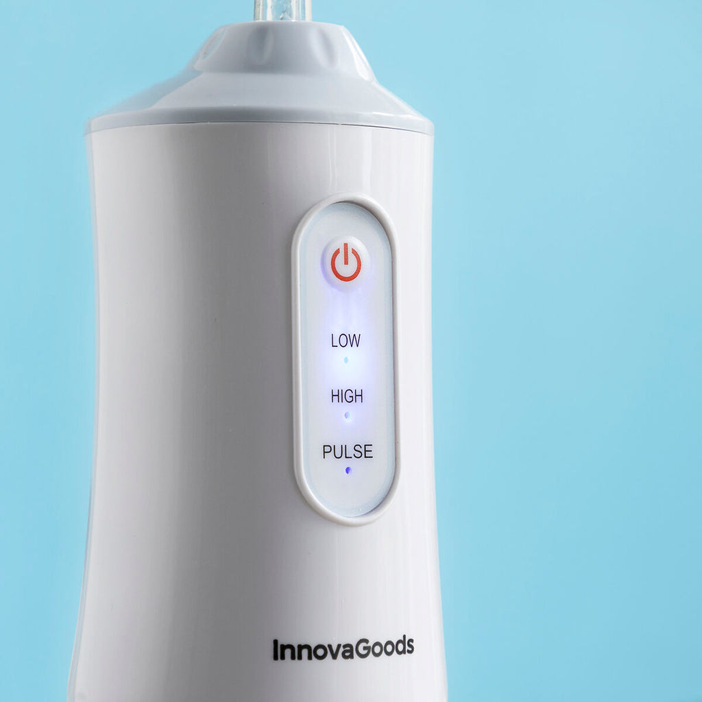 Portable blue and white cordless water flosser with interchangeable cleaning heads and USB cable. — view 9