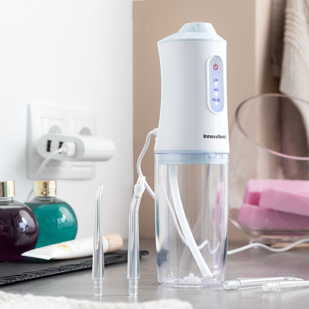 Portable blue and white cordless water flosser with interchangeable cleaning heads and USB cable. — view 7